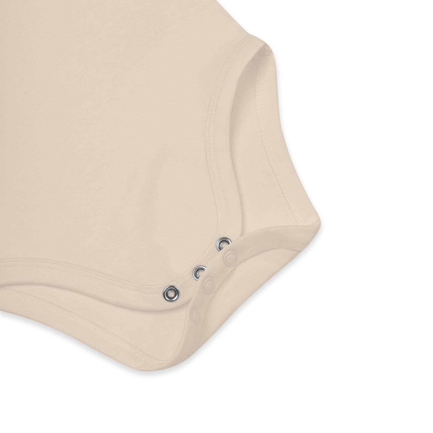 Detalle de la pernera con tres corchetes del body de bebé, confeccionado en algodón orgánico, y en color natural o beige. Los cierres son a presión y metalizados.